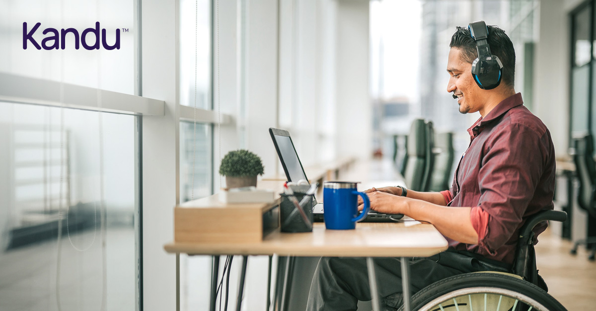 Stroke survivor in a wheelchair wearing headphones and working on a laptop, illustrating independence and focus during stroke recovery.
