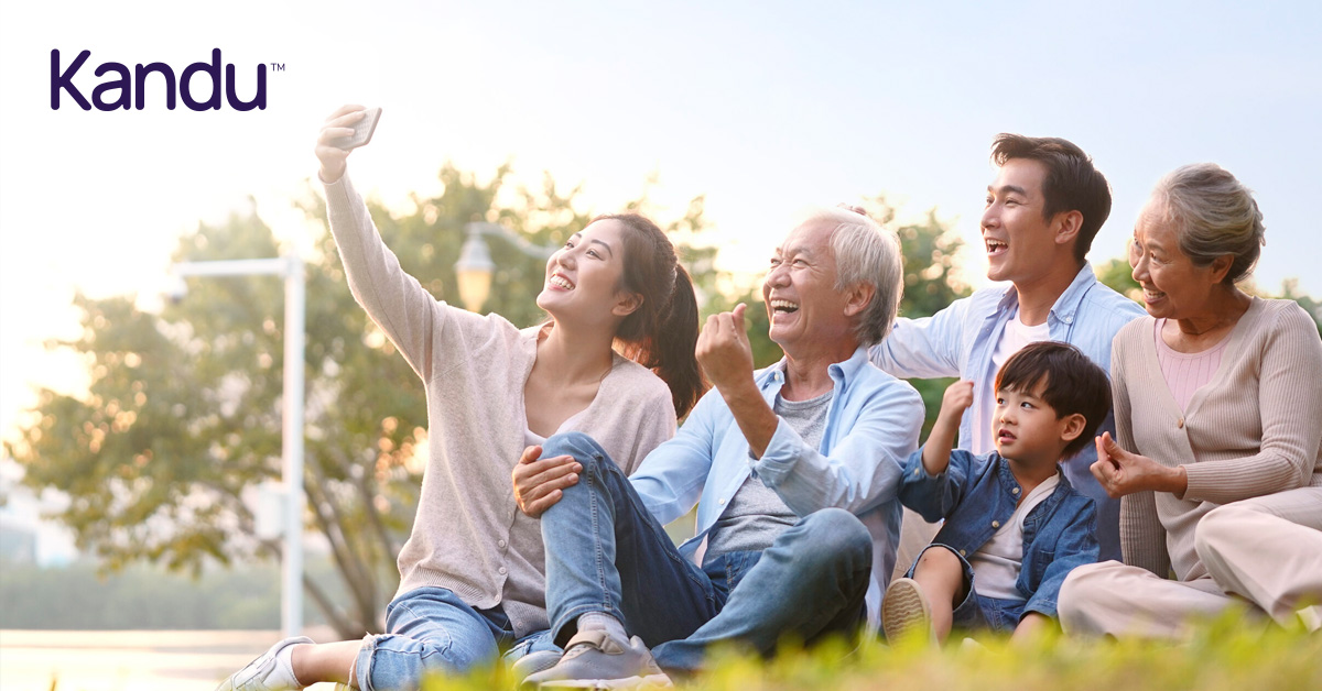Multigenerational family sitting outdoors, smiling and taking a selfie, symbolizing support and joy in stroke recovery.